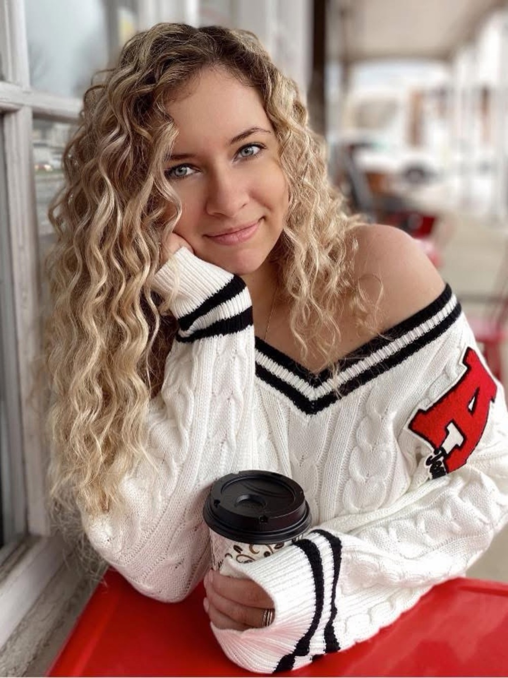 Adika White Cable-Knit Off-Shoulder Sweater with Black Trim and Red Patch